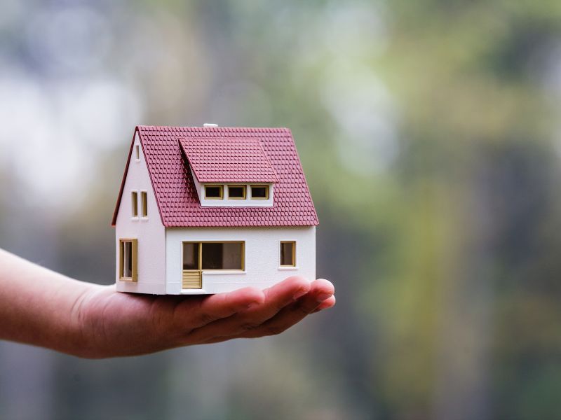 Jak marketing dla deweloperów wspiera biznes mieszkaniowy? Na zdjęciu makieta domu na dłoni.
