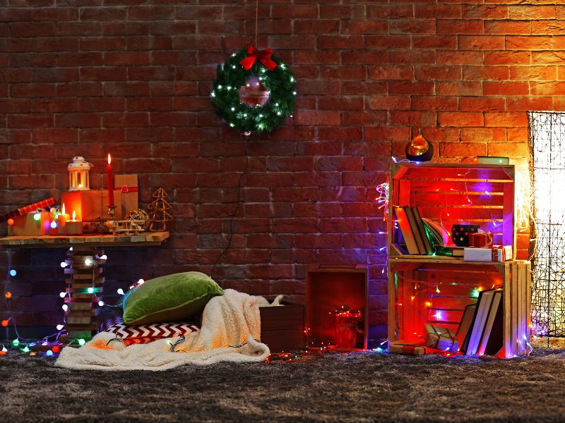 Jak dobrać lamki świąteczne do pokoju? Na zdjęciu świąteczna lamki w pokoju ze ścianą z cegłami.